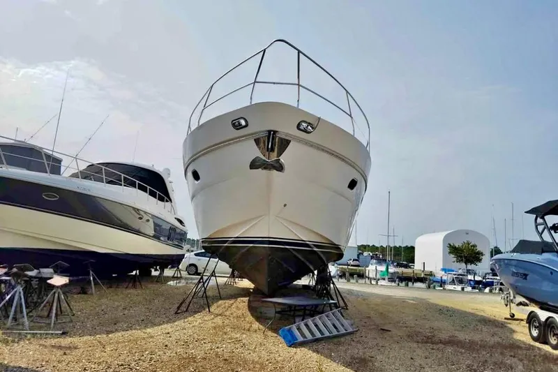  Yacht Photos Pics 2004 Viking Princess 61 Fly Bridge yacht on dry dock, surrounded by other boats.