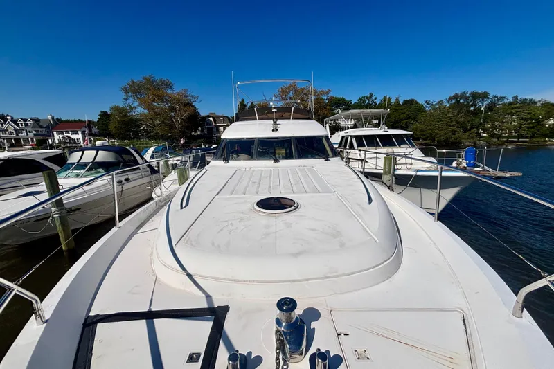  Yacht Photos Pics 2004 Viking Princess 61 Fly Bridge yacht docked at marina under clear blue sky.