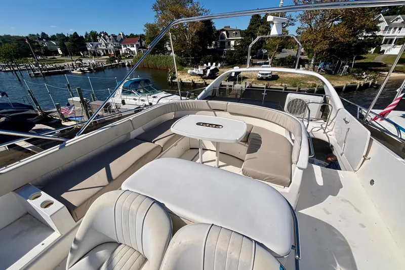  Yacht Photos Pics 2004 Viking Princess 61 Fly Bridge yacht with spacious seating and scenic marina view.