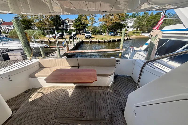  Yacht Photos Pics 2004 Viking Princess 61 Fly Bridge yacht with outdoor seating and wooden table.