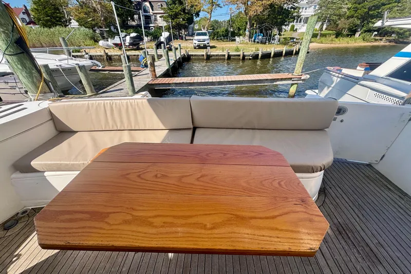  Yacht Photos Pics Luxurious 2004 Viking Princess 61 Fly Bridge yacht with elegant outdoor seating and wooden table.