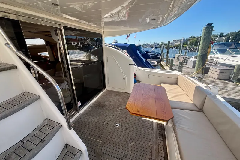  Yacht Photos Pics 2004 Viking Princess 61 Fly Bridge yacht with outdoor seating and dock view.