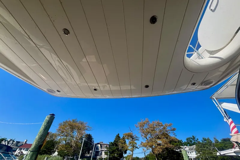  Yacht Photos Pics 2004 Viking Princess 61 Fly Bridge yacht underside against clear blue sky.