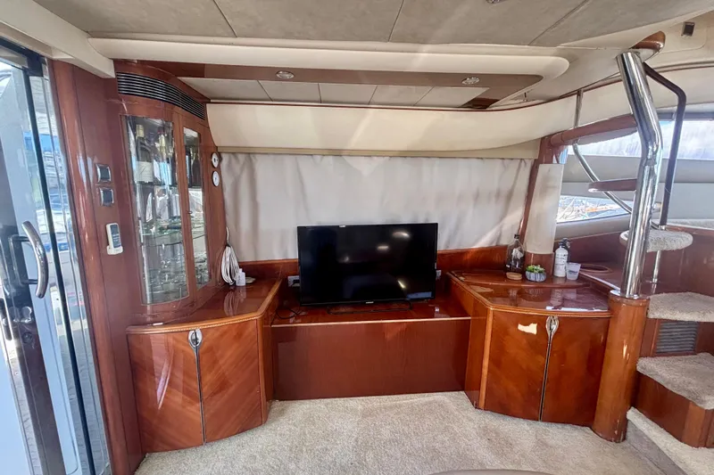  Yacht Photos Pics Luxurious interior of 2004 Viking Princess 61 Fly Bridge yacht with TV and wooden cabinetry.
