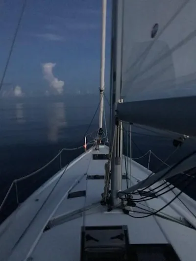  Yacht Photos Pics Sailing on Jeanneau Sun Odyssey 51, 2017 model, in calm waters at dusk.