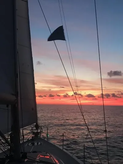  Yacht Photos Pics Jeanneau Sun Odyssey 51 sailing at sunset, 2017 model, with vibrant sky and ocean view.