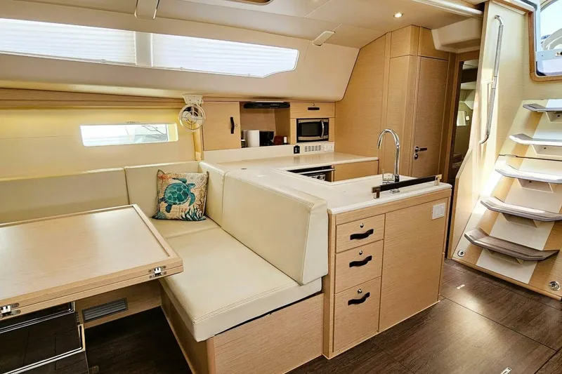  Yacht Photos Pics Luxurious interior of 2017 Jeanneau Sun Odyssey 51 yacht with modern kitchen and seating area.