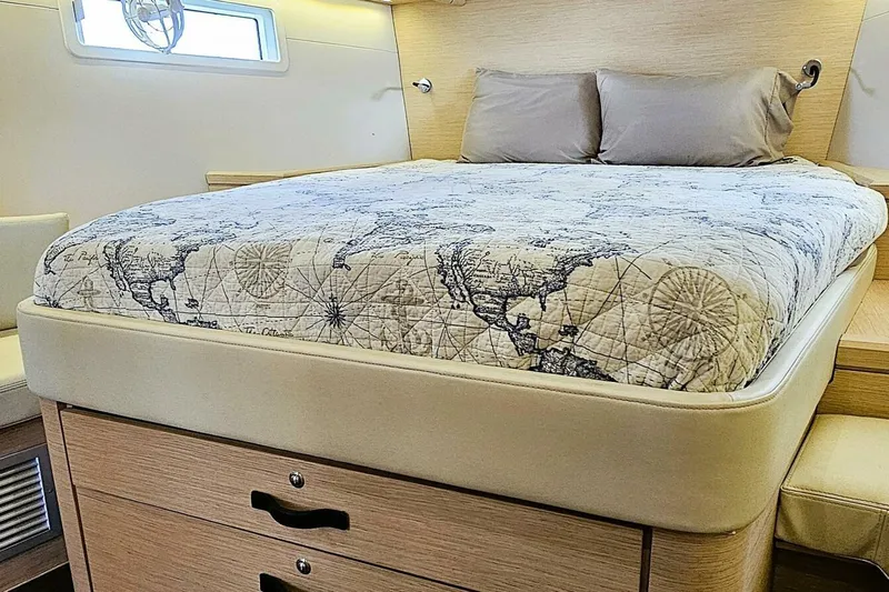  Yacht Photos Pics Luxurious cabin interior of 2017 Jeanneau Sun Odyssey 51 with map-themed bedding.
