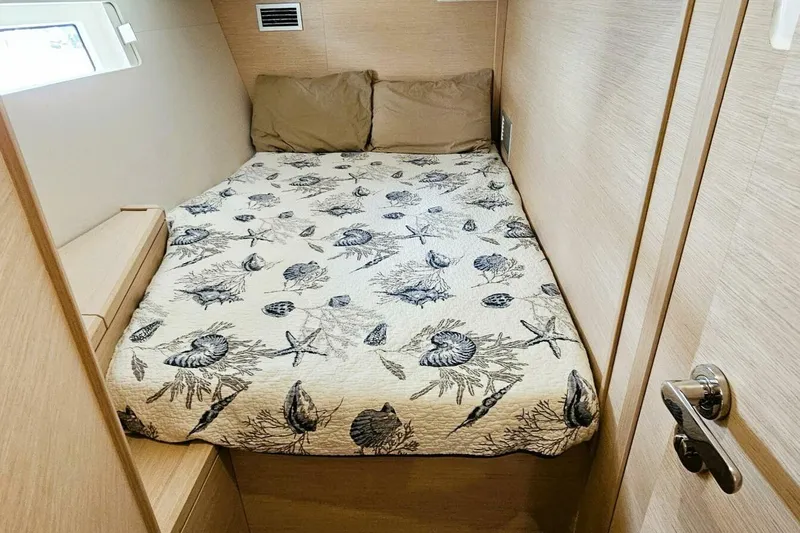  Yacht Photos Pics Cozy cabin bedroom in 2017 Jeanneau Sun Odyssey 51 yacht with nautical-themed bedding.