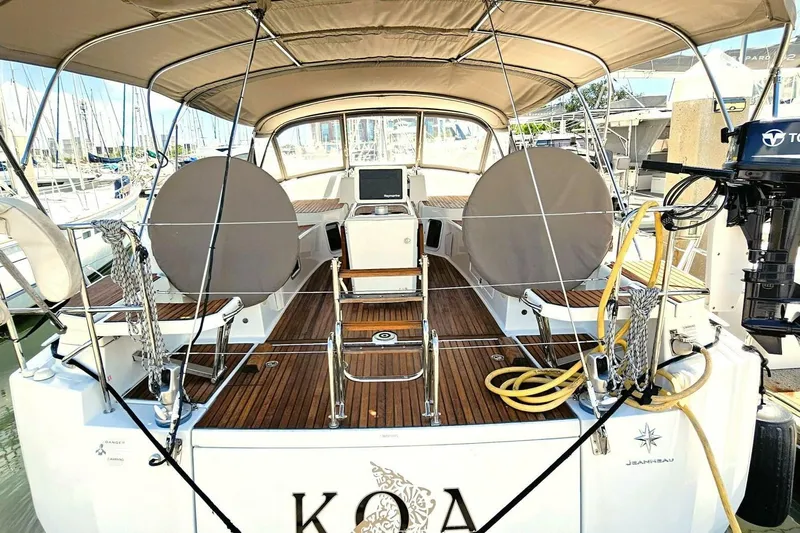  Yacht Photos Pics Jeanneau Sun Odyssey 51 sailboat, 2017 model, docked with covered seating and equipment.