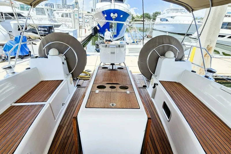  Yacht Photos Pics 2017 Jeanneau Sun Odyssey 51 yacht cockpit with wooden deck and dual steering wheels.