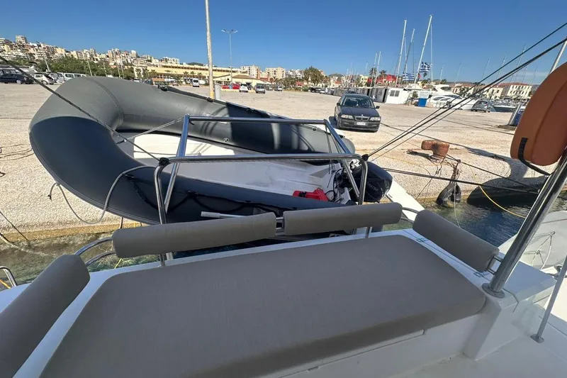 Yulia Yacht Photos Pics 2023 Bali 4.2 yacht docked at marina with inflatable boat and cityscape background.