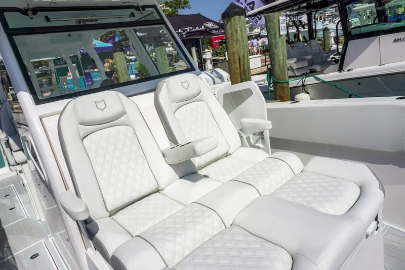 The Reel Commander Yacht Photos Pics 2026 Sea Fox 368 Commander boat with luxurious white seating at a marina.