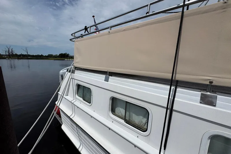Carolina Breeze Yacht Photos Pics 1989 Grand Banks 42 Motor Yacht docked by calm waters under a cloudy sky.
