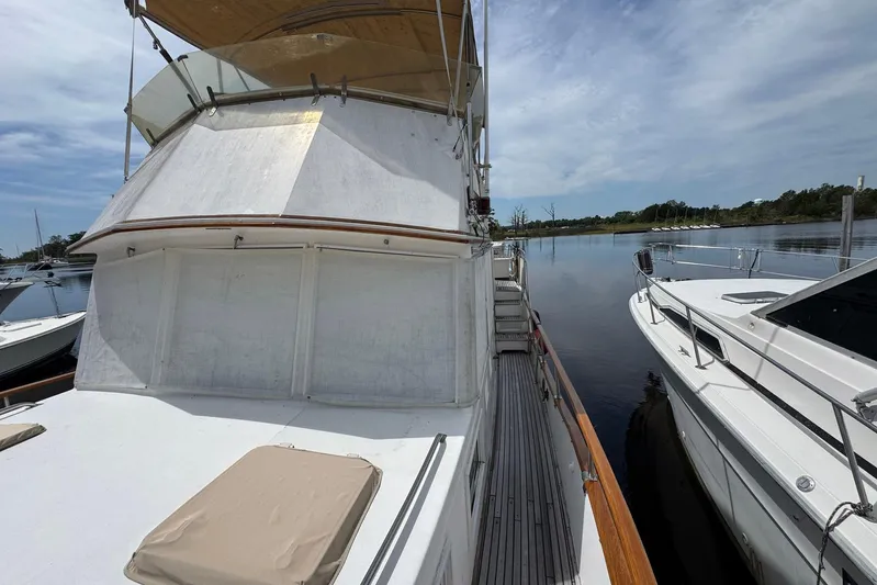 Carolina Breeze Yacht Photos Pics 1989 Grand Banks 42 Motor Yacht docked beside another boat on a calm lake.