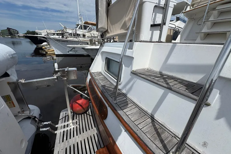 Carolina Breeze Yacht Photos Pics 1989 Grand Banks 42 Motor Yacht docked, showcasing wooden steps and marina surroundings.