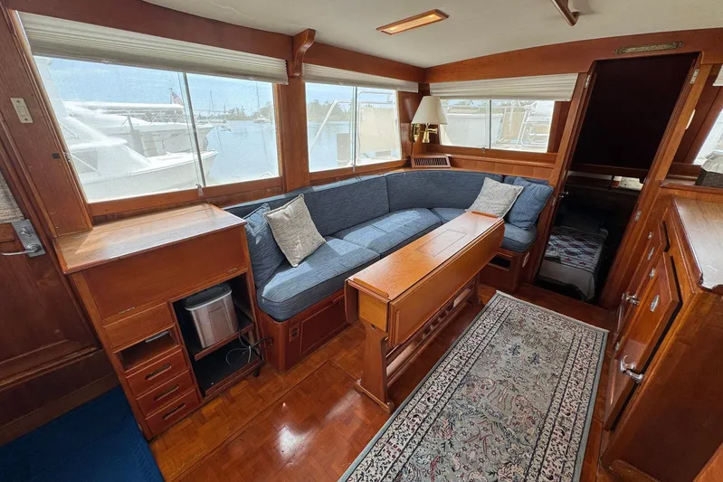 Carolina Breeze Yacht Photos Pics 1989 Grand Banks 42 Motor Yacht interior with wooden furnishings and blue cushioned seating.