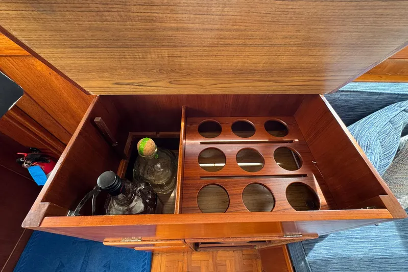 Carolina Breeze Yacht Photos Pics Wooden liquor cabinet on 1989 Grand Banks 42 Motor Yacht, featuring bottle storage slots.