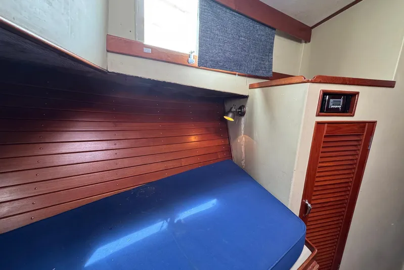 Carolina Breeze Yacht Photos Pics 1989 Grand Banks 42 Motor Yacht cabin with wooden paneling and blue mattress.