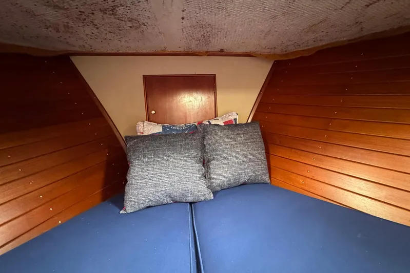 Carolina Breeze Yacht Photos Pics Cozy cabin interior of 1989 Grand Banks 42 Motor Yacht with wooden paneling and cushions.