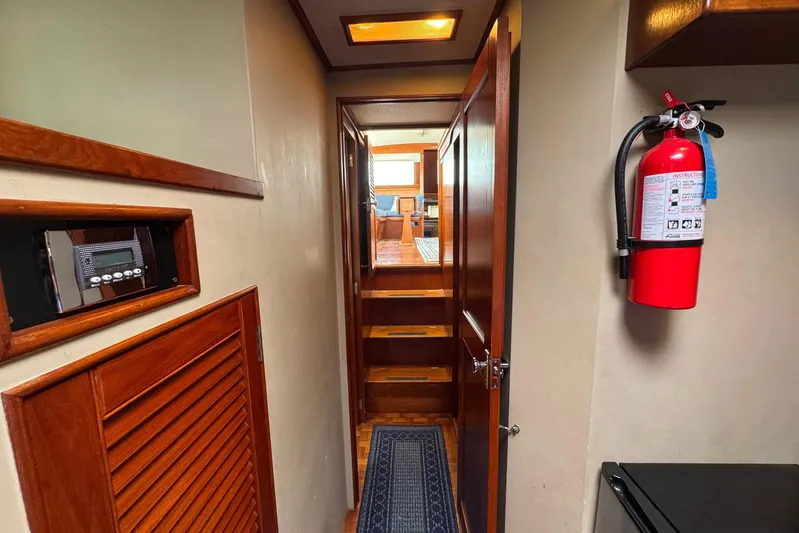 Carolina Breeze Yacht Photos Pics 1989 Grand Banks 42 Motor Yacht interior hallway with fire extinguisher and wooden accents.
