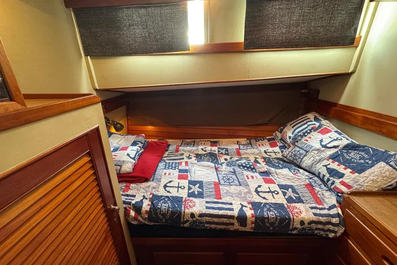 Carolina Breeze Yacht Photos Pics Cozy cabin interior of 1989 Grand Banks 42 Motor Yacht with nautical-themed bedding.