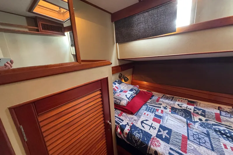 Carolina Breeze Yacht Photos Pics Cozy cabin interior of 1989 Grand Banks 42 Motor Yacht with nautical-themed bedding.