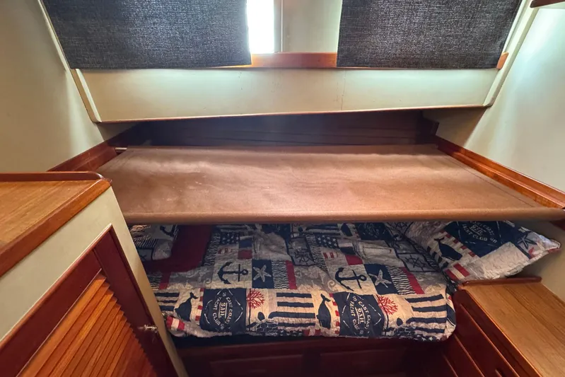 Carolina Breeze Yacht Photos Pics Cozy cabin interior of 1989 Grand Banks 42 Motor Yacht with nautical-themed bedding.