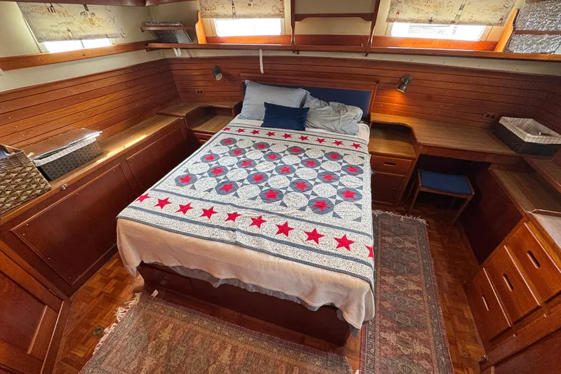 Carolina Breeze Yacht Photos Pics Cozy bedroom in 1989 Grand Banks 42 Motor Yacht with quilted bedspread and wooden furnishings.