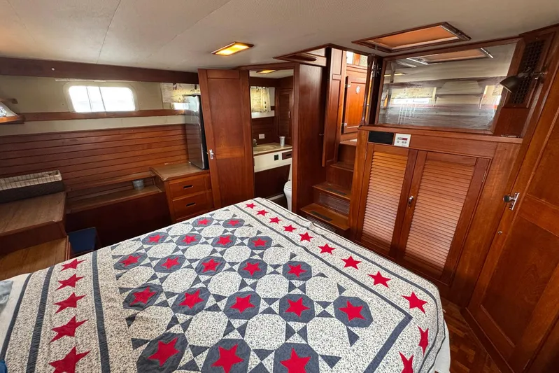 Carolina Breeze Yacht Photos Pics Interior of 1989 Grand Banks 42 Motor Yacht with wooden cabinetry and star-patterned bedspread.
