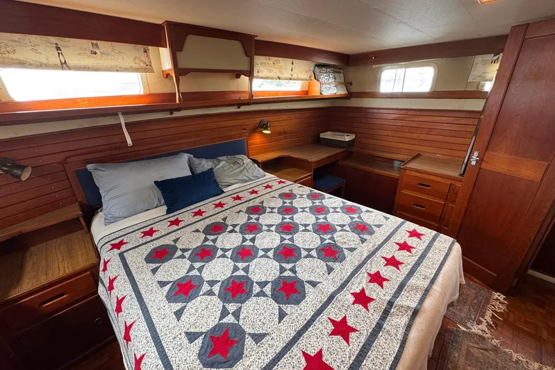 Carolina Breeze Yacht Photos Pics Cozy bedroom in 1989 Grand Banks 42 Motor Yacht with star-patterned quilt and wooden interior.