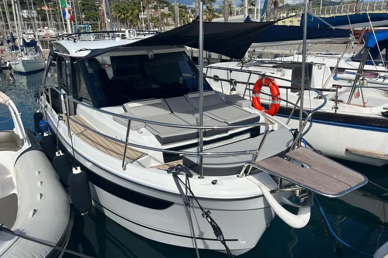  Yacht Photos Pics 2024 Jeanneau Merry Fisher 895 docked at marina, featuring sleek design and sunshade.