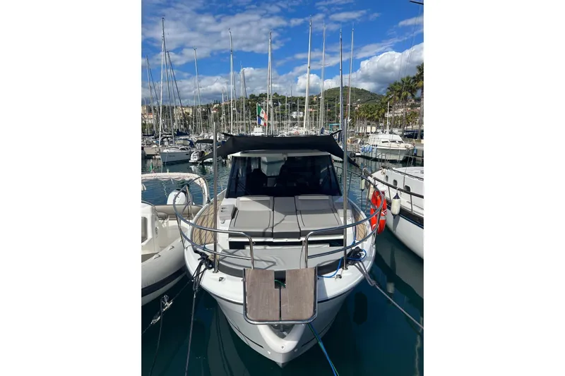  Yacht Photos Pics 2024 Jeanneau Merry Fisher 895 docked in a marina, surrounded by sailboats.