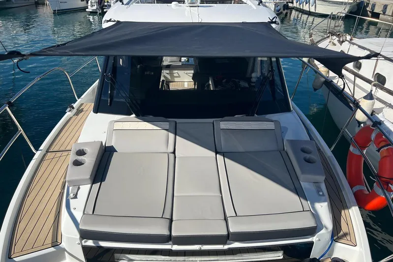  Yacht Photos Pics 2024 Jeanneau Merry Fisher 895 with sunshade and cushioned deck, docked at marina.