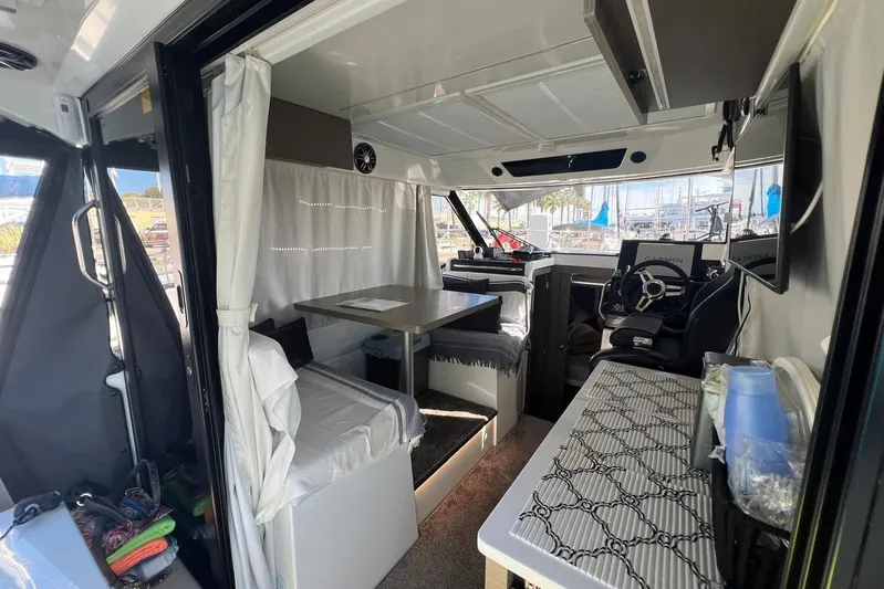  Yacht Photos Pics Interior of 2024 Jeanneau Merry Fisher 895, featuring helm, seating, and dining area.