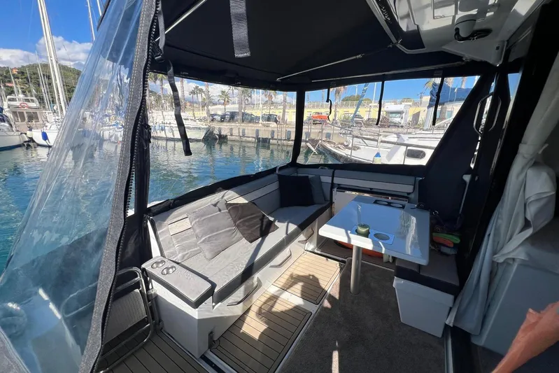  Yacht Photos Pics 2024 Jeanneau Merry Fisher 895 cockpit with seating, table, and marina view.