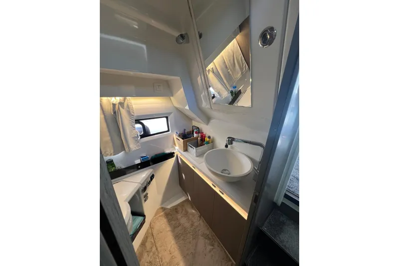  Yacht Photos Pics 2024 Jeanneau Merry Fisher 895 bathroom with modern sink, mirror, and window.