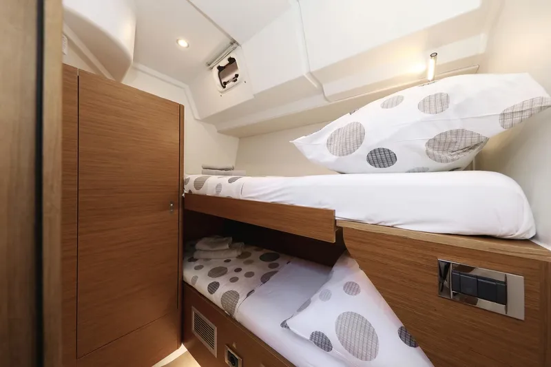 Volare Yacht Photos Pics 2025 Hanse 590 yacht interior with cozy wooden bunk beds and polka dot bedding.