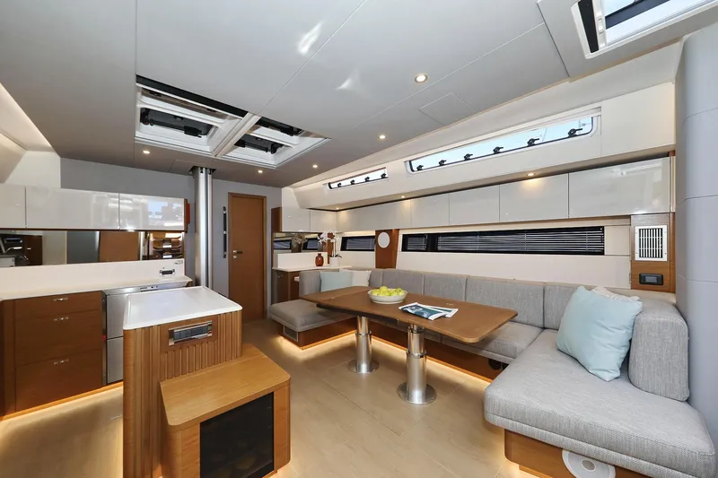 Volare Yacht Photos Pics Luxurious interior of 2025 Hanse 590 yacht with modern kitchen and cozy seating area.