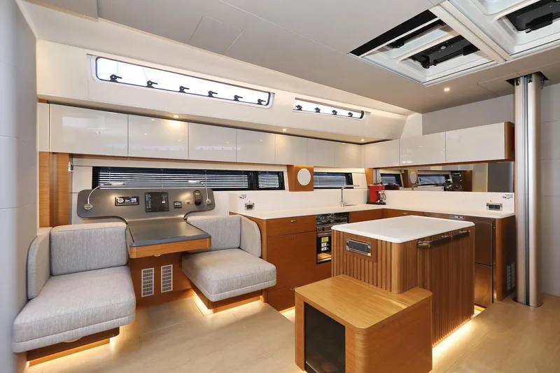 Volare Yacht Photos Pics Luxurious interior of 2025 Hanse 590 yacht with modern kitchen and seating area.