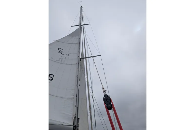 Skoal Yacht Photos Pics Sailboat mast and rigging of 2004 Cabo Rico 42 against cloudy sky.