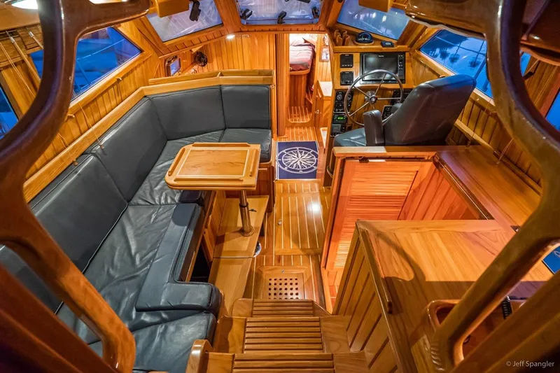 Skoal Yacht Photos Pics Luxurious interior of 2005 Cabo Rico 42 Pilot yacht with wooden finishes and leather seating.