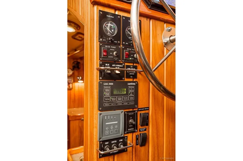 Skoal Yacht Photos Pics Control panel of a 2005 Cabo Rico 42 Pilot yacht with wooden finish and steering wheel.