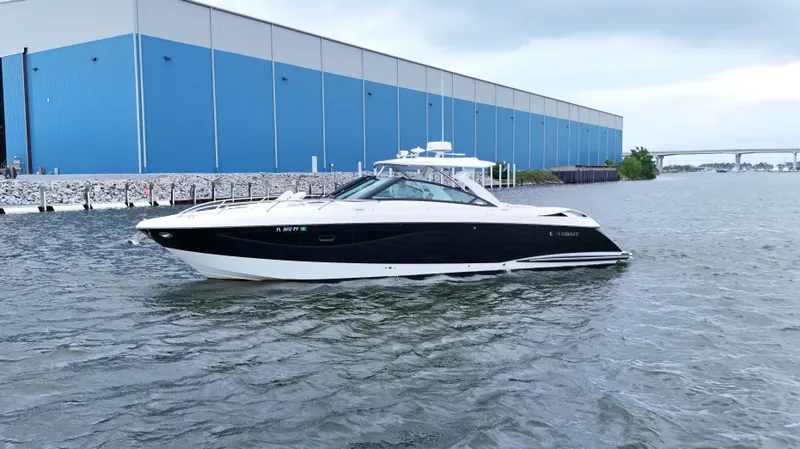  Yacht Photos Pics 2015 Cobalt A40 boat on water near a large blue warehouse.