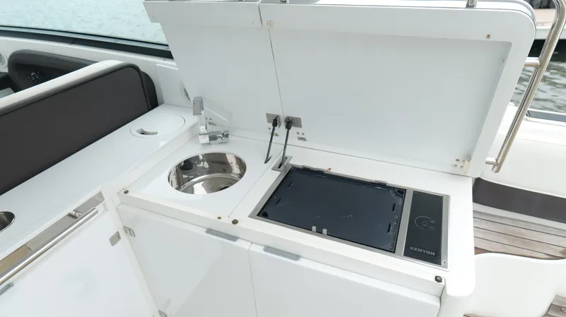  Yacht Photos Pics 2015 Cobalt A40 yacht kitchenette with sink and stove, open storage compartment.