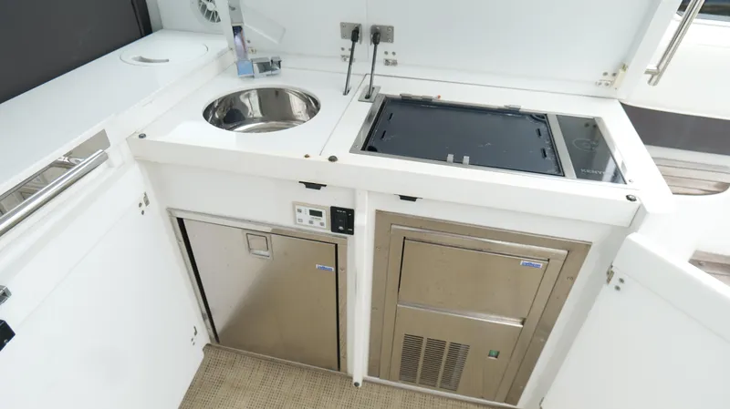  Yacht Photos Pics 2015 Cobalt A40 yacht kitchenette with sink, stove, and stainless steel appliances.