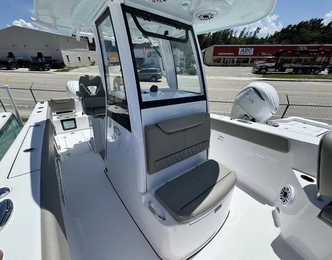  Yacht Photos Pics 2025 Sportsman Heritage 261 boat interior with seating and console, parked near a road.