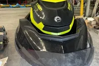 2014 Sea-Doo 260 RXT jet ski in a garage, black and yellow design.
