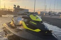 2014 Sea-Doo 260 RXT jet ski at sunset near a marina.