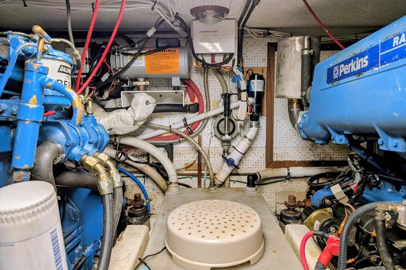 Positive Space Yacht Photos Pics Engine room of a 1987 DeFever Trawler with Perkins marine engines and various mechanical components.